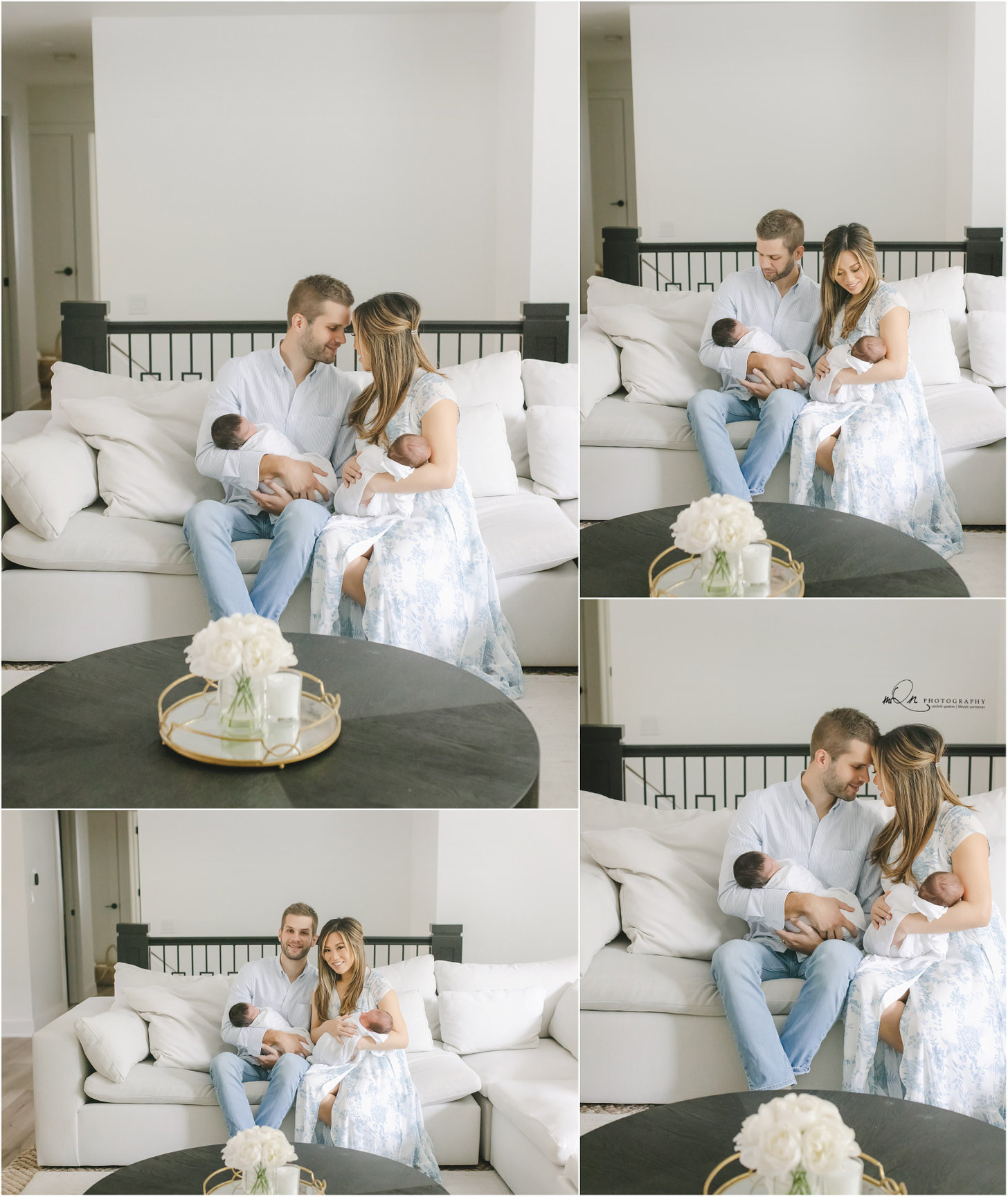 A couple sitting on a white sofa, holding a baby, with a minimalistic living room background.