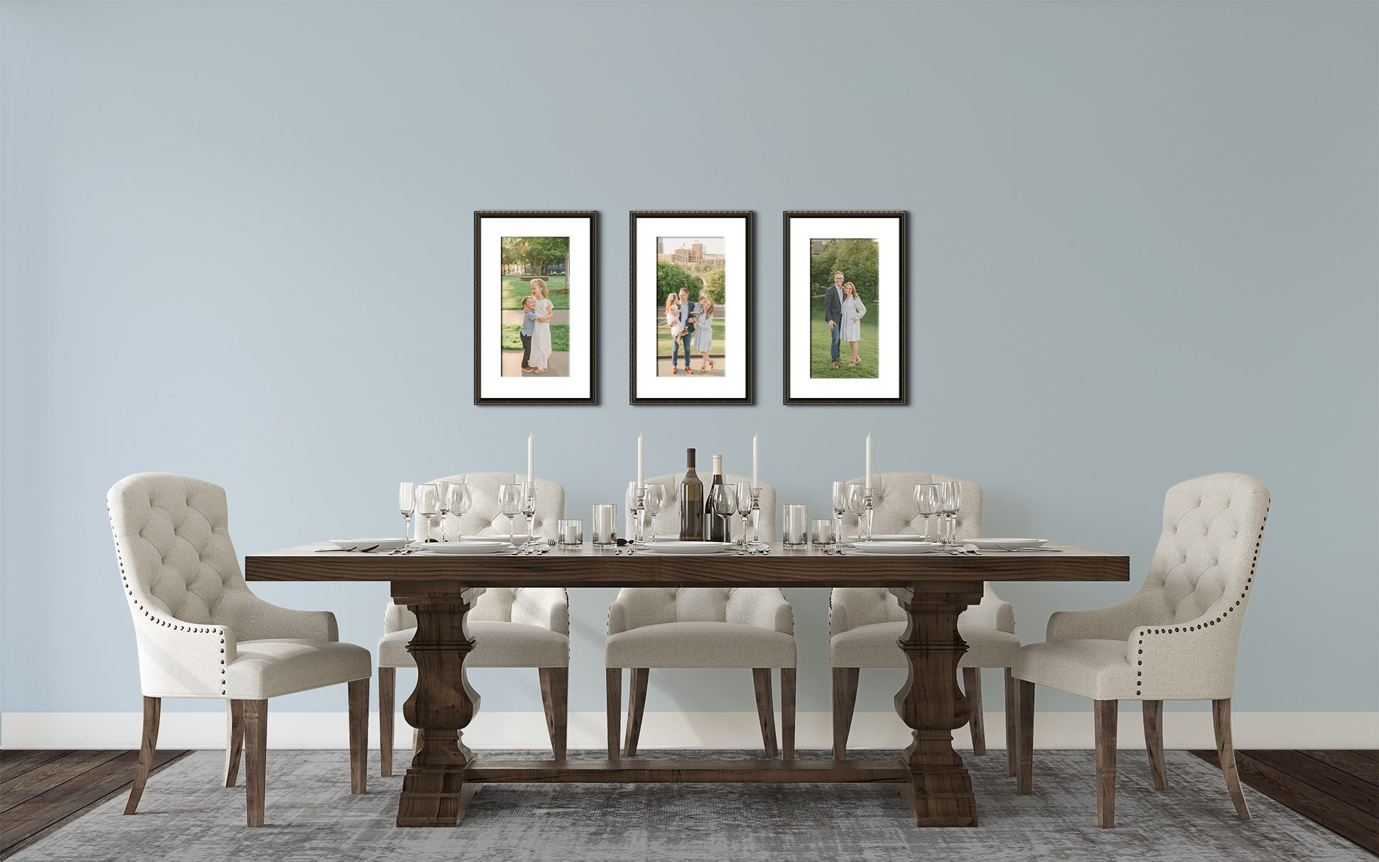 Elegant dining room with a wooden table, white chairs, and framed artwork on a light blue wall.