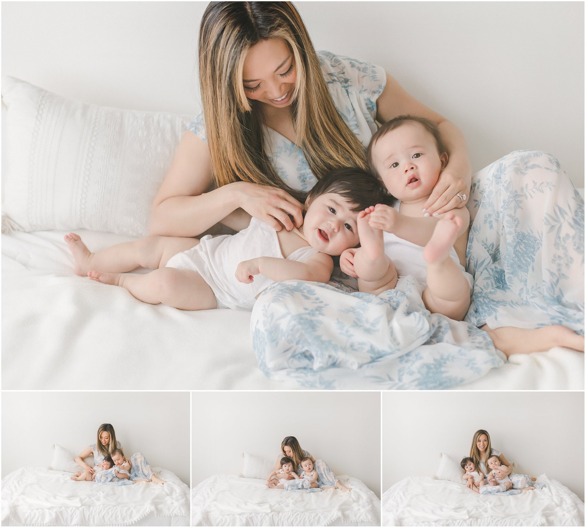 A woman sitting on a bed with two babies in white clothing, smiling and interacting with them.