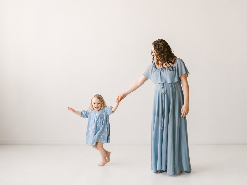 Preparing for Baby’s Arrival in the Twin Cities Pregnant mom and toddler in blue dresses during a Twin Cities maternity photography session in studio.