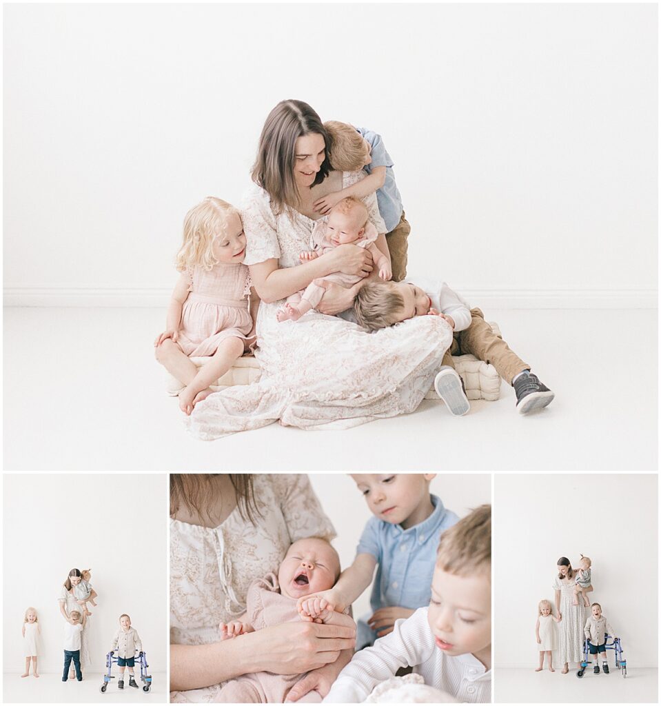 Minneapolis motherhood photographer photographing a mama holding her baby while her three children gather close in a white studio