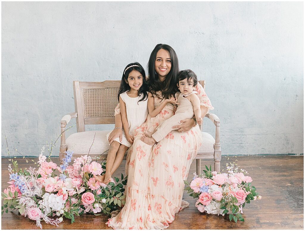 Motherhood Session in Minneapolis featuring a mom with her two children in a floral studio setup at a NE Minneapolis photography studio