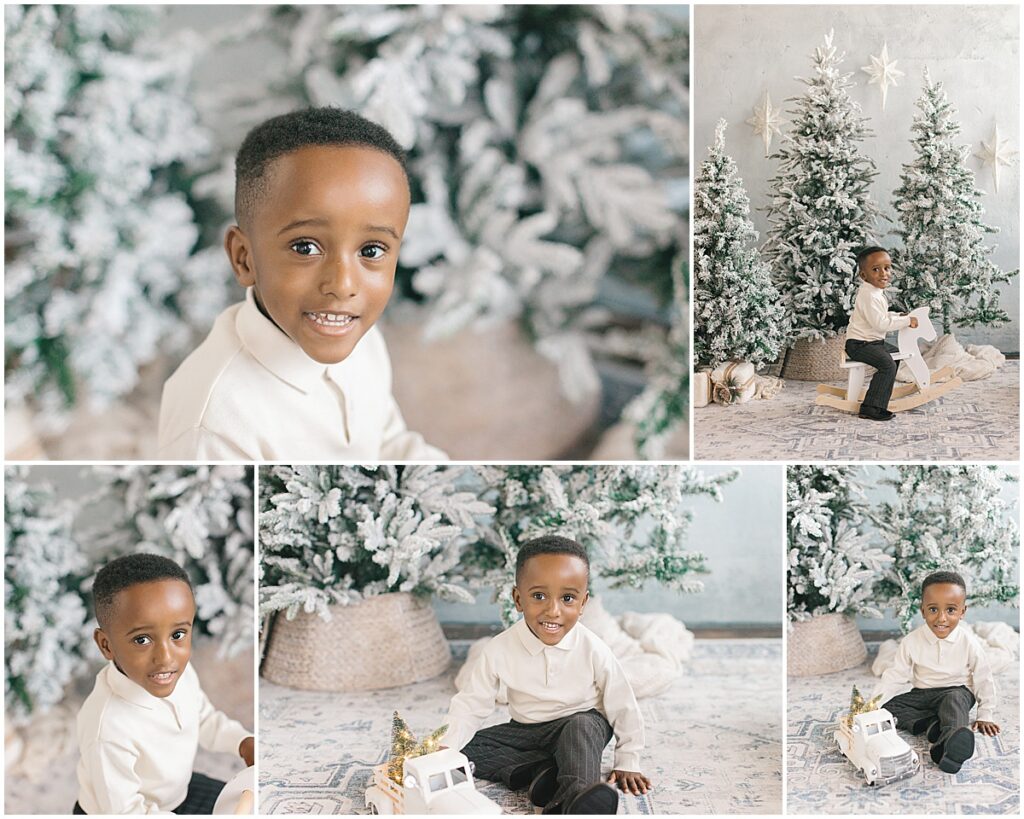 Young boy smiling and playing beside flocked Christmas trees during a Minneapolis holiday mini session.