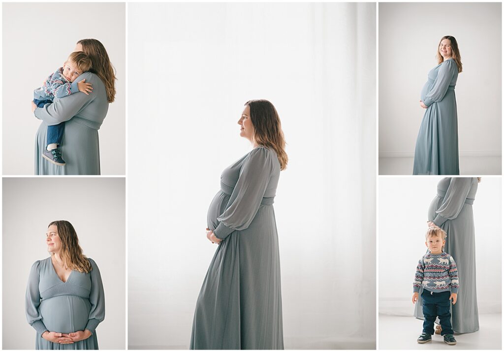 Pregnant mother in a blue dress holding her young son during a studio maternity session.