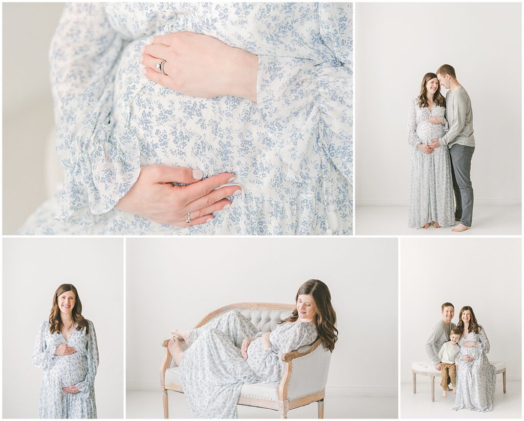 Pregnant mother in a blue floral dress posing with her partner and young son in a studio.