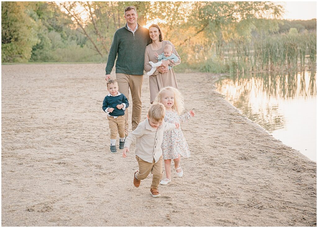 Lake Ann Park family photos of a family walking along the beach at sunset